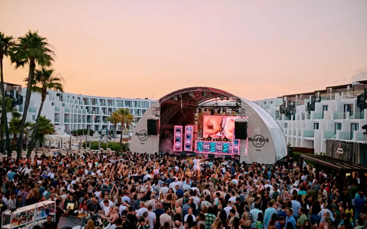 Children of the 80's show at the Hard Rock hotel in Ibiza, with a big crowd dancing to a lit up stage during sunset