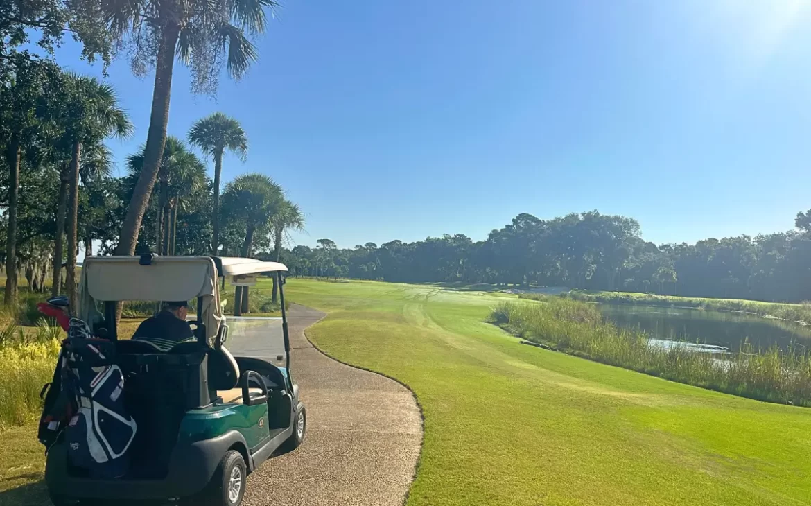 Golf cart on the Cougar Point golf course with the sun shining in the back
