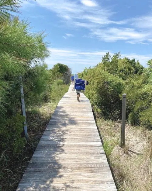 A person walking down the entry boardwalk to Beachwalker Park