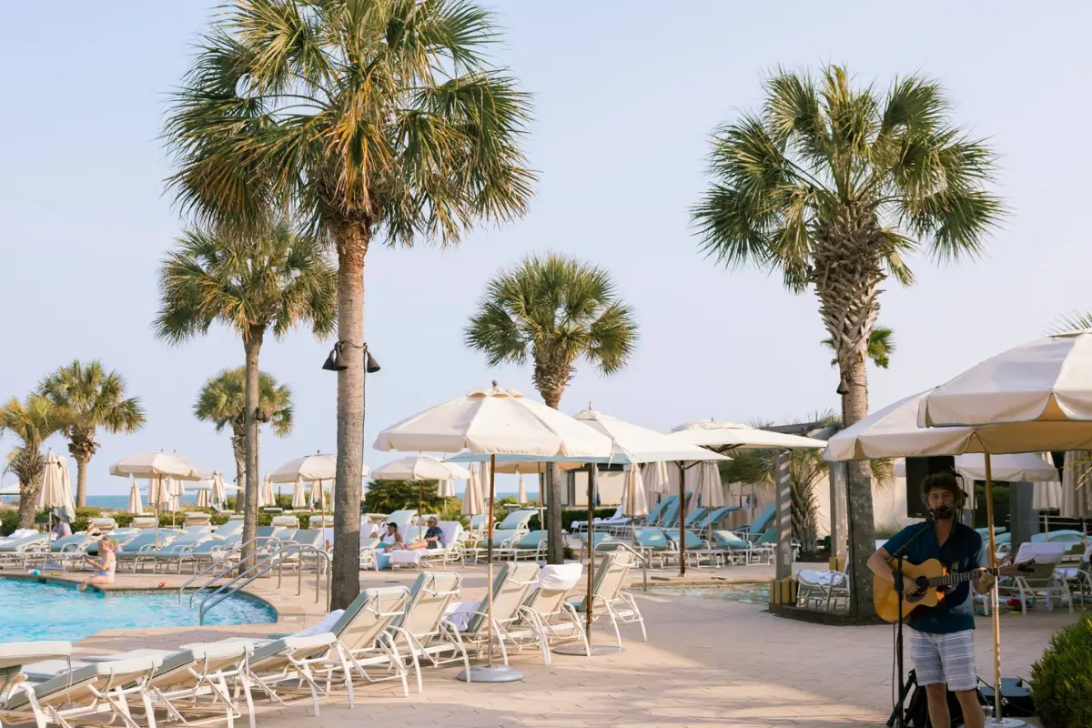 Cover image for Where to Stay On Kiawah Island blog, showing the pool and a live musician at The Sanctuary